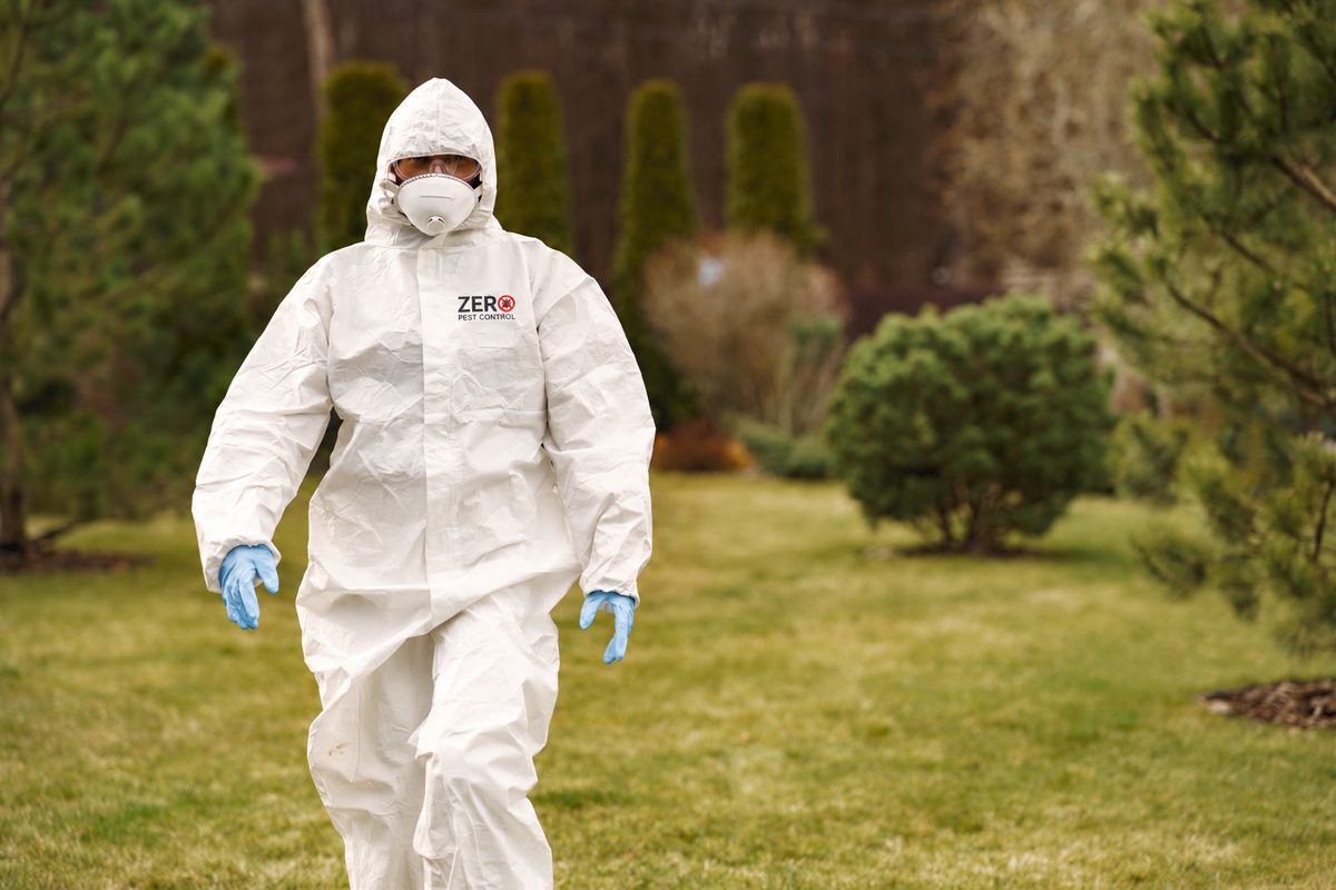 Zero Pest Control technician in full protective equipment on a property