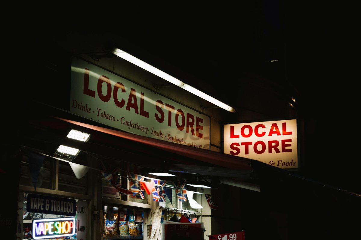 Lit storefront sign of a local retail store