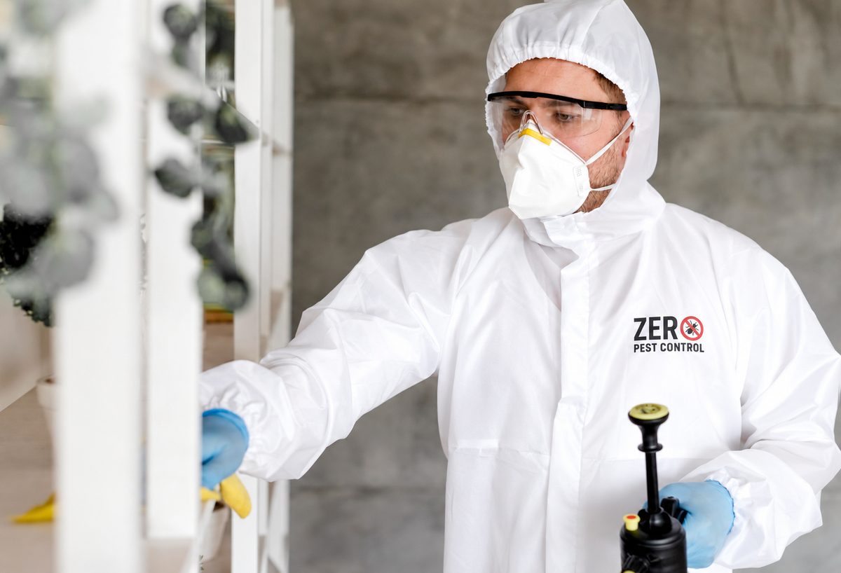 Zero Pest Control technician treating shelving inside a home